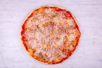 Pizza fish with pieces of a salmon and onions, strewed an oregano