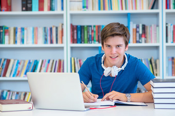 student preparing exam and learning lessons in school library, making research on laptop and browse internet 