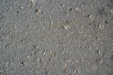 Texture of a gray, even, granular dry road asphalt.