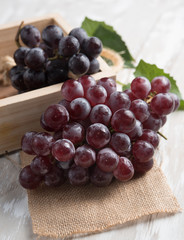 Ripe black grapes on a wooden background