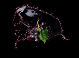 Fototapeta premium Bunch of grapes with red juice splash isolated on black background