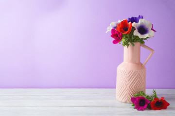 Spring flowers bouquet on wooden table with copy space over purple background