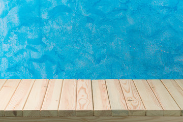 Empty wooden table over blue painted wall background.