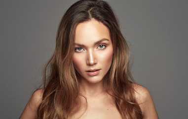 Portrait of beautiful young girl with long hair looking at camera