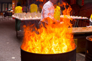 Chinese traditional religious beliefs, devout believers help prepare the ritual sacrifices, burn...