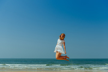 Beautiful Joyfull Girl Jumping on The Beach. Vacation and Relaxing