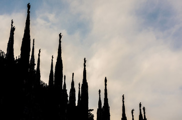Beautiful Milan Cathedral gothic pinnacles stand out against the afternoon clouds