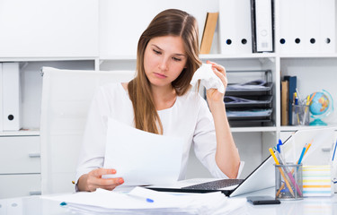 Upset young businesswoman in office