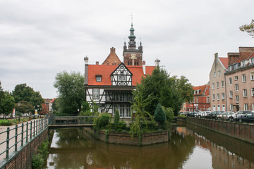 A house is surrounded by water. Bridges, channels, river, houses, street and park.