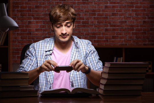 Young handsome student preparing for exams at night 