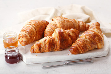 fresh croissants with jars of jam