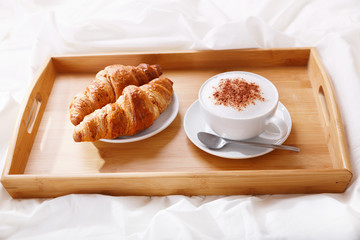 breakfast tray in bed : cappuccino and croissants