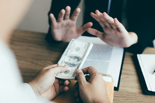 Businessperson refusing bribe given money by partner with anti bribery corruption concept.