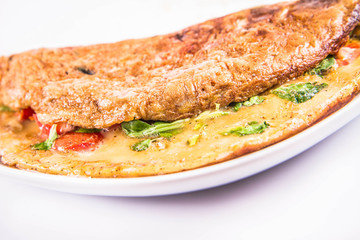 Omelette with tomatoes and fresh corn salad on a white background