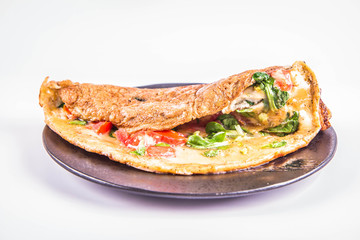 Omelette with tomatoes and fresh corn salad on a white background