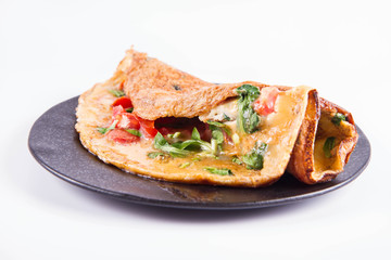 Omelette with tomatoes and fresh corn salad on a white background
