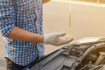 Mechanic hand checking oil level ,Driver on the road having problem with a car. Man checks the oil level in the engine,copy space.