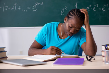 Black female student in front of chalkboard  