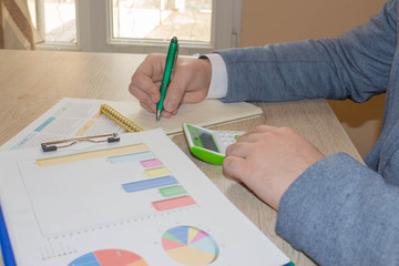 Close up view of bookkeeper or financial inspector hands making report, calculating or checking balance
