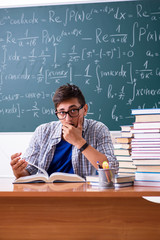 Young male student studying math at school