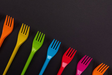 Many color plastic forks on a bright background