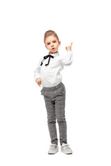 Beautiful little girl dressed like a School girl - in white shirt and gray pants, rounded glasses standing near white wall and posing like model thumb up, point finger.