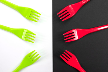 Bright green and red forks isolated on black and white background