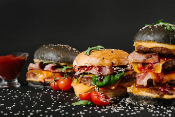 Many different burgers with ingredients on a black background