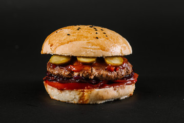 Tasty burger on the black background