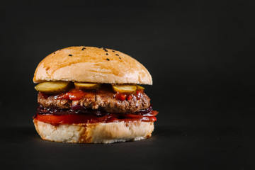 Tasty burger on the black background