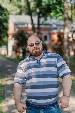 .Young man with round glasses and overweight in the park.