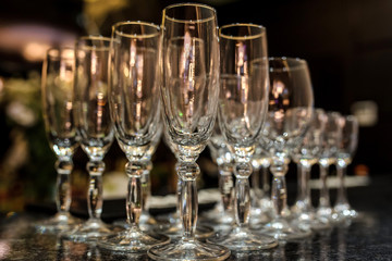 close up photo of rows of empty glasses for champagne on the table