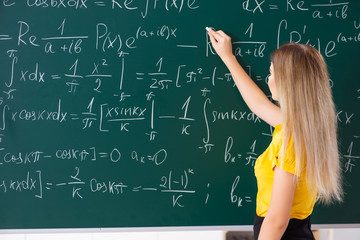 Young female student in front of the chalkboard