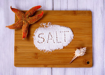 crumbly salt on a cutting Board with a seashell and a starfish