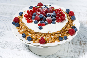 healthy oatmeal cake with yoghurt and fresh berries on a stand, top view
