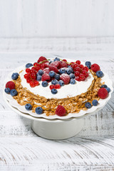 healthy oatmeal cake with yoghurt and fresh berries on a stand, vertical top view