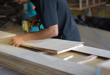 Fototapeta na wymiar Hand of carpenter working with furniture wood.