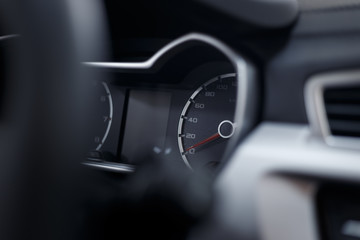 Glowing beautiful dashboard of a modern expensive car. The interior of the car. The foreground is blurred. Modern car interior details. Car detailing. Selective focus