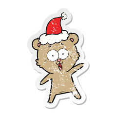 laughing teddy  bear distressed sticker cartoon of a wearing santa hat