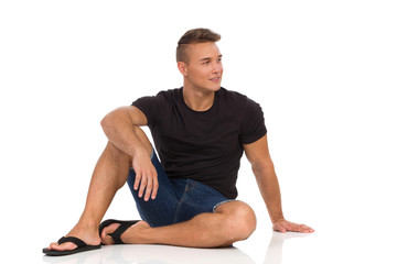 Fototapeta premium Relaxed Man Is Sitting On A Floor And Looking Away