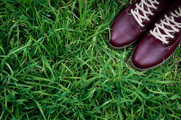 pair of red boots on the green grass, upper point of view