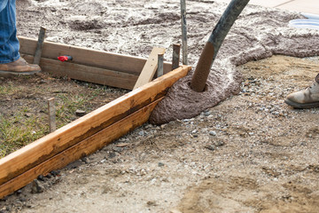 Construction Worker Pouring Wet Deck Cement Into Wooden Frame