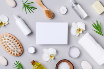 Obraz na płótnie Canvas Spa, aromatherapy, beauty treatment and wellness background with massage brush, towel, orchid flowers and cosmetic products. Top view and flat lay. Empty card for text.