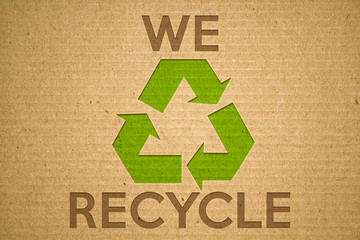 Recycle green symbol on cardboard with text we recycle