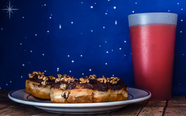 Fototapeta na wymiar Three doughnuts and juice for breakfast on the board walk.