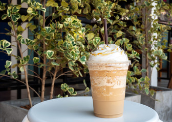 Cappuccino blended in plastic cup. Served with whipped cream. Refreshment drink. Favorite caffeine...