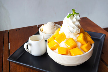 Shaved ice dessert with mango sliced.  Served with vanilla ice cream and whipped cream.