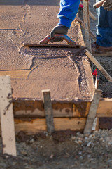 Construction Worker Smoothing Wet Cement With Trowel Tools