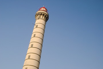 Topo de um farol com céu azul de fundo