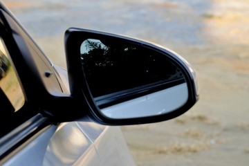 A wing mirror of a car with warm light and blur ground floor background 